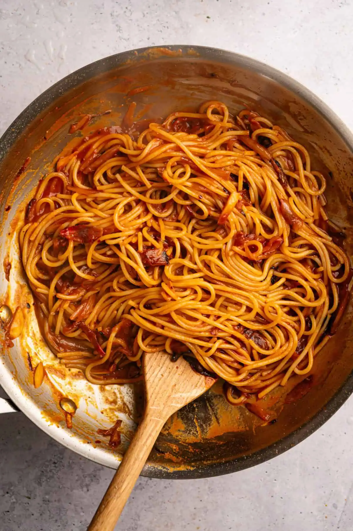Caramelized shallot pasta tossed in a pan.