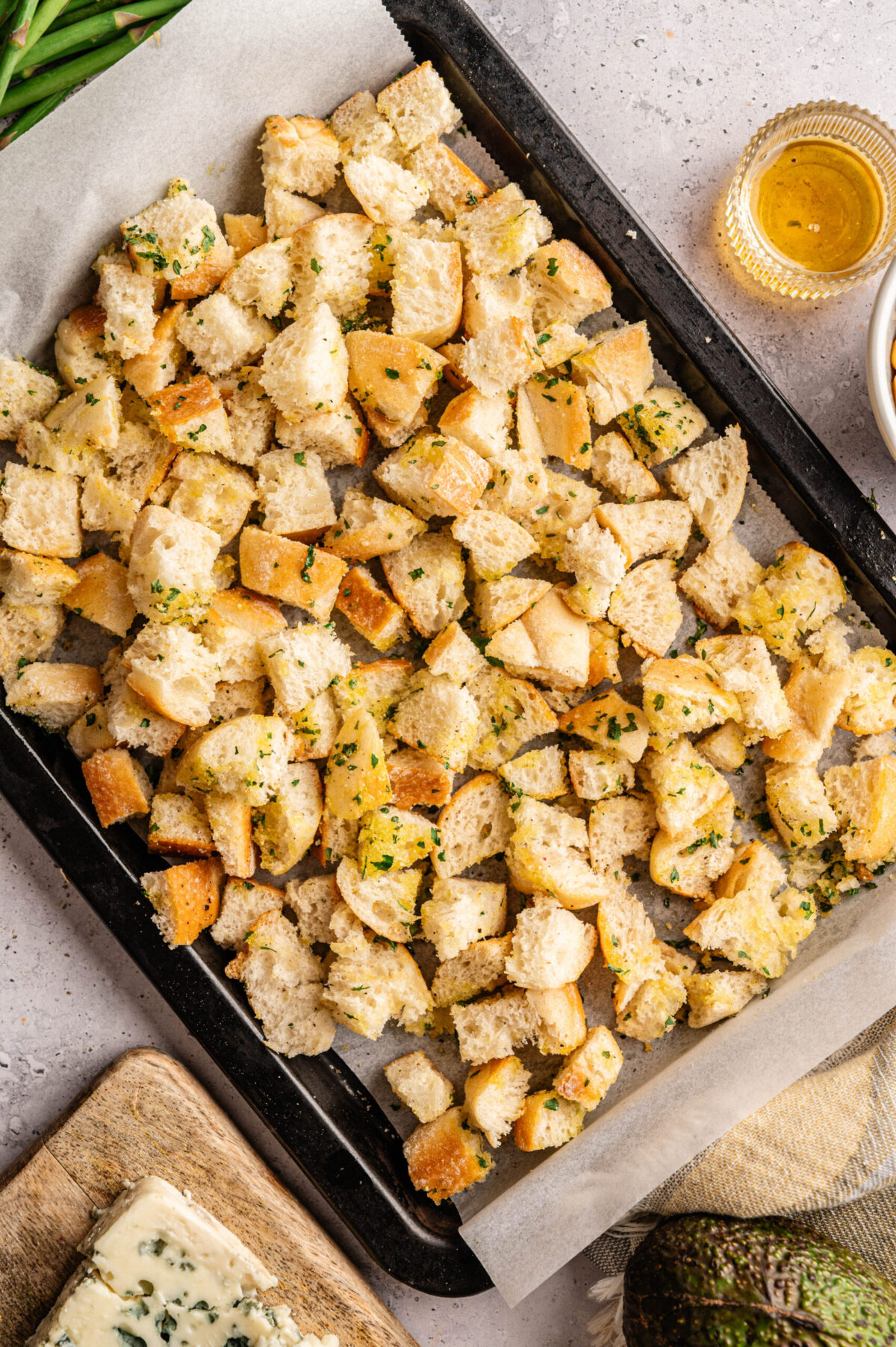 Cubed bread on a sheet pan with seasonings.