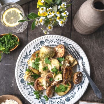 Creamy artichokes and potatoes garnished with parsley.
