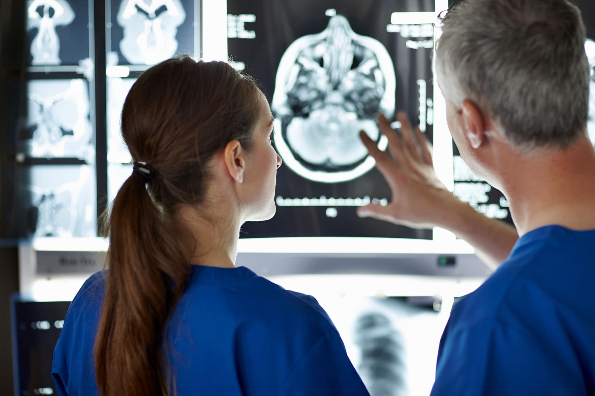Medical professionals reviewing brain scan images in a healthcare setting.