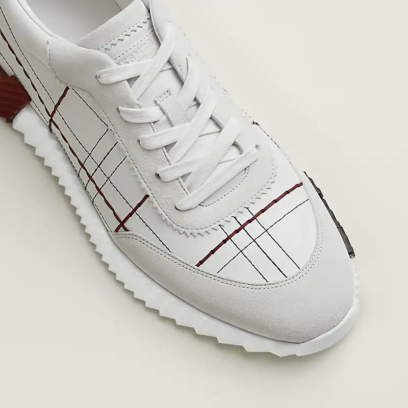Elegant Hermès bouncing sneakers in white with red and black plaid accents. Perfect for stylish casu.
