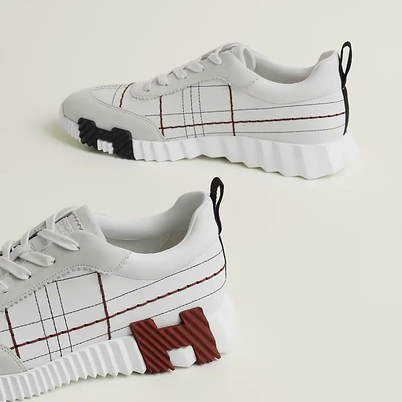 Stylish Hermès bouncing white sneakers with red and black accents. Perfect for casual and luxury str.