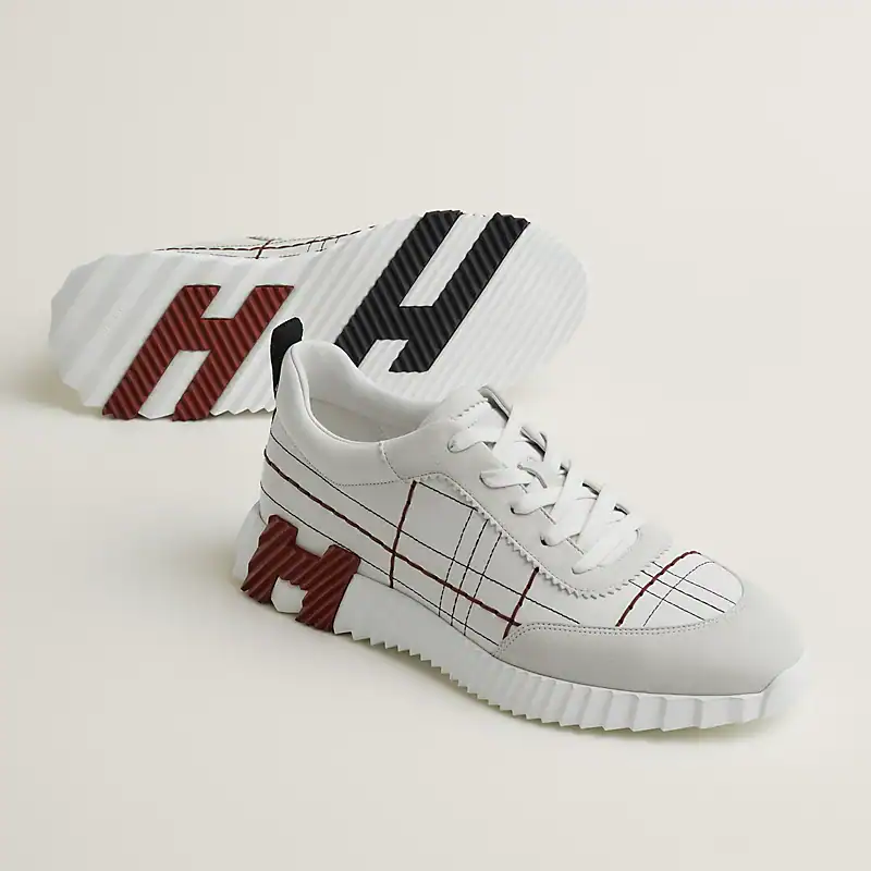 Bouncing Hermès sneakers in white with red and black accents, stylish and comfortable for casual wea.