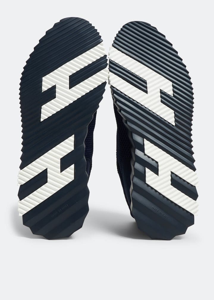 Bouncing Hermès sneakers in black and white with textured soles.