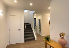 Comfortable modern interior with staircase and greenery, promoting connection and friendship.