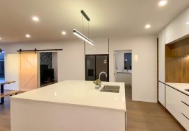 Bright-modern-kitchen-with-island-and-wood-panel-wall-creating-warm-and-inviting-home-ambiance.