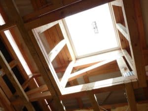 Bright skylight in wooden roof framing supporting friendship and community building.