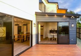 Modern family home with outdoor deck and large sliding glass doors, ideal for family living and entertainment.