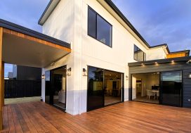 Modern family home with spacious outdoor deck, large sliding glass doors, and contemporary design.