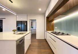 Modern minimalist kitchen with white cabinetry and wooden accents, ideal for family and social gatherings.