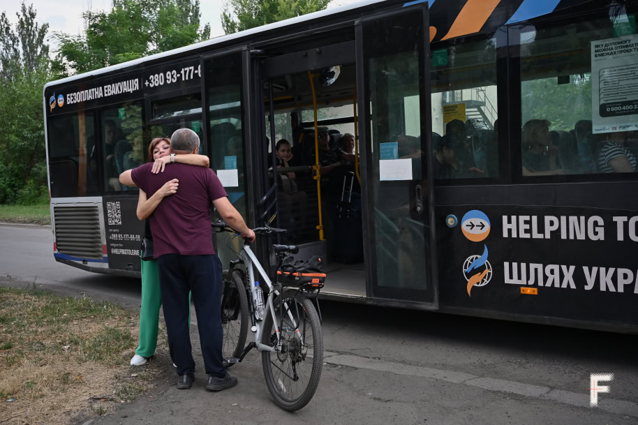 Люди обіймаються перед посадкою в евакуаційний автобус, Добропілля, Донецька область, Україна, 18 липня 2025 р. Фото Анна Семенюк / Frontliner