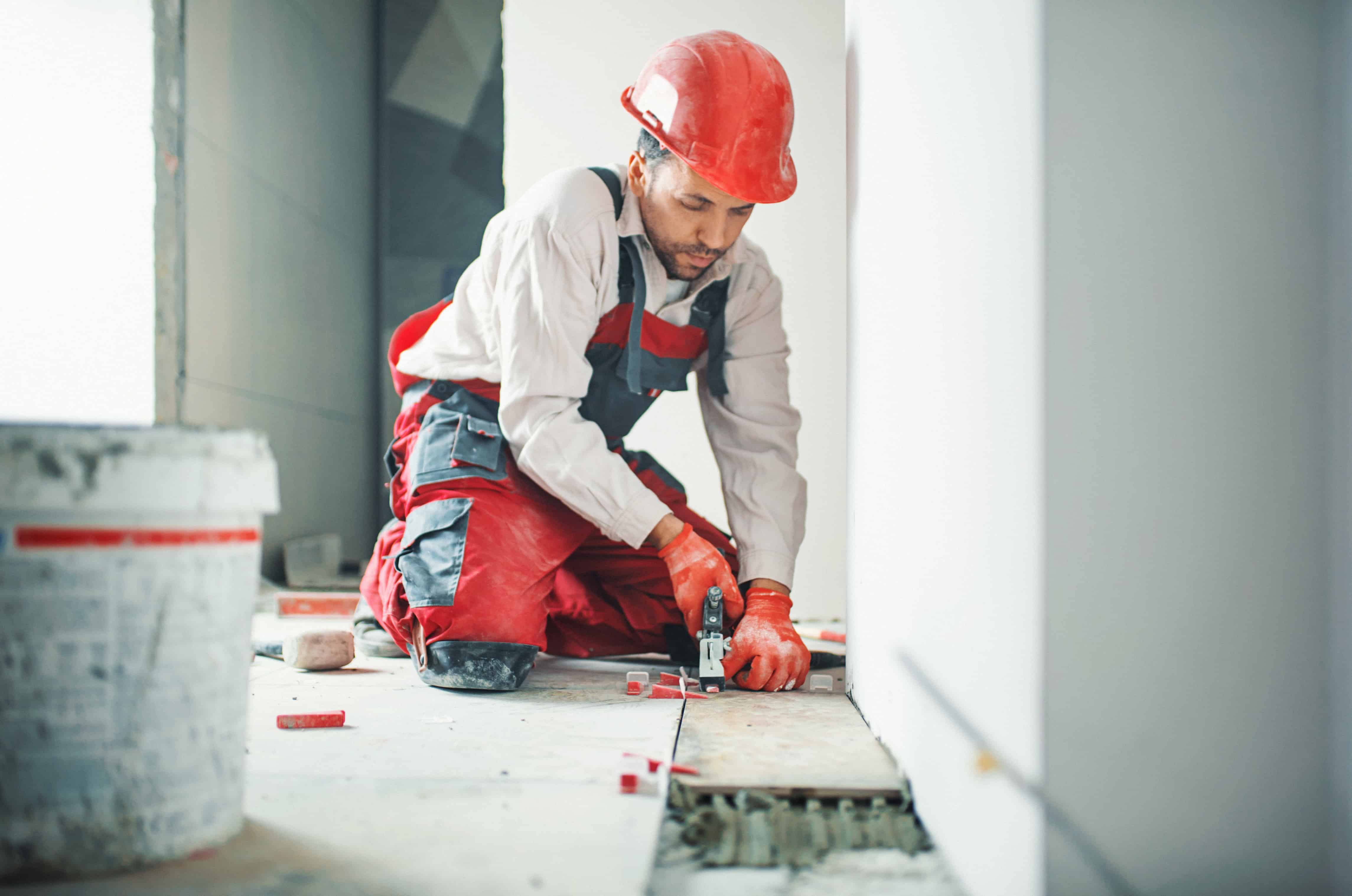 Handyman installing ceramic tiles.
