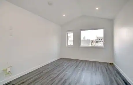 Spacious interior with natural light, sleek grey flooring, and new white walls, ideal for living or office space.