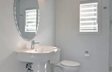 Bright bathroom featuring a modern sink, mirror, and natural light from window.