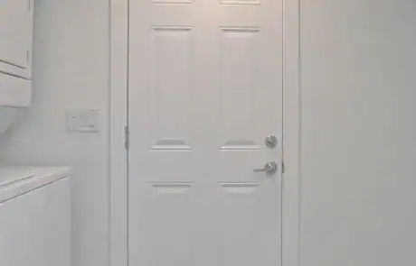 White interior door with six panels and silver hardware.