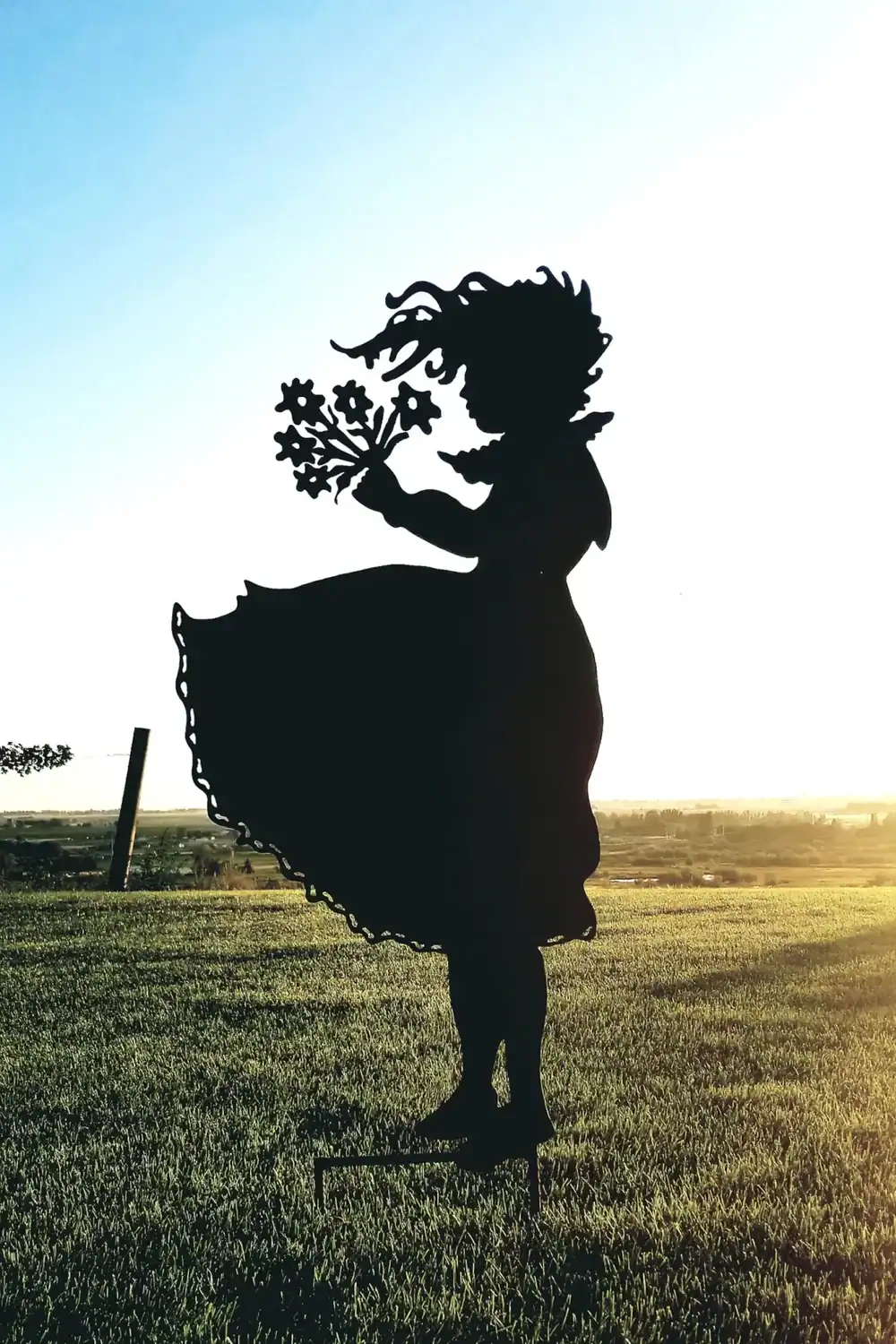 Whimsical Girl Silhouette Sculpture Enchanting girl silhouette sculpture with floral details in garden art.