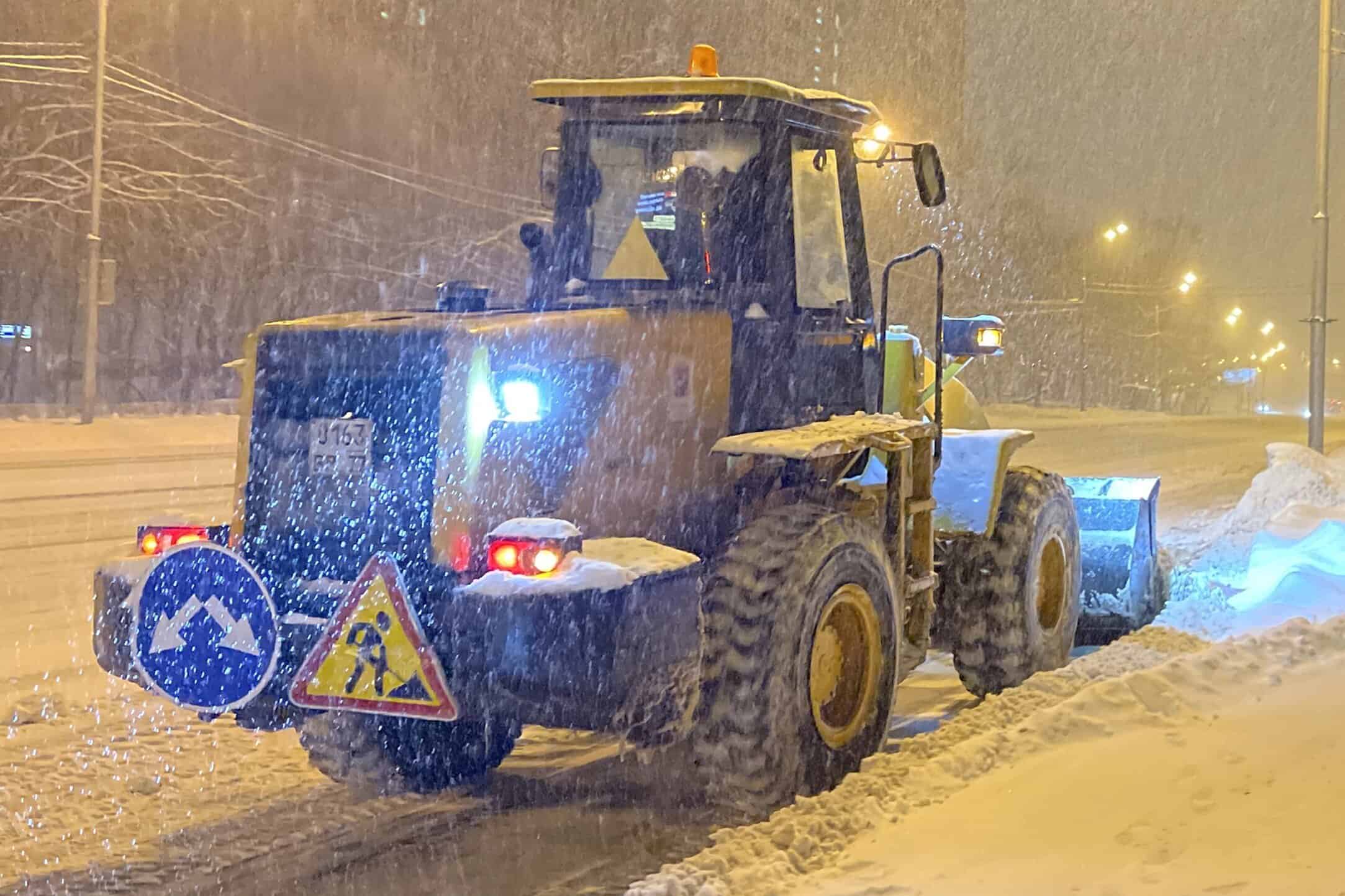 En plogbil som röjer snö under pågående snöfall