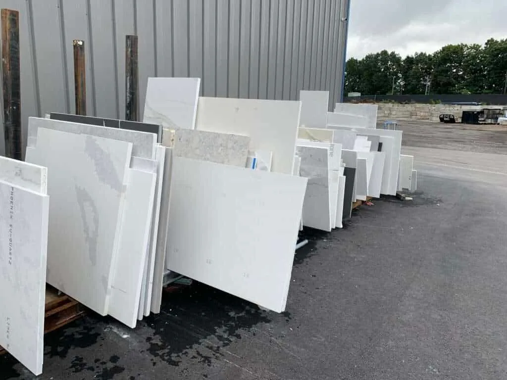 slabs of marble and granite stacked outside of building