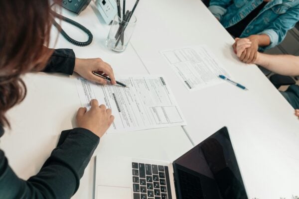 A legal professional assists clients with paperwork at a law office, representing the beginning of the legal process for individuals injured in Massachusetts. This image reflects the supportive and confidential attorney-client relationship at Gavagan Law, LLC, where immigration status does not affect your right to pursue a personal injury claim.
