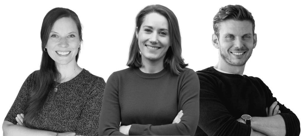 Jane, Nina und Tobias, das Team von Gehirngerecht. Sie haben alle die Arme verschränkt und lächeln in die Kamera.