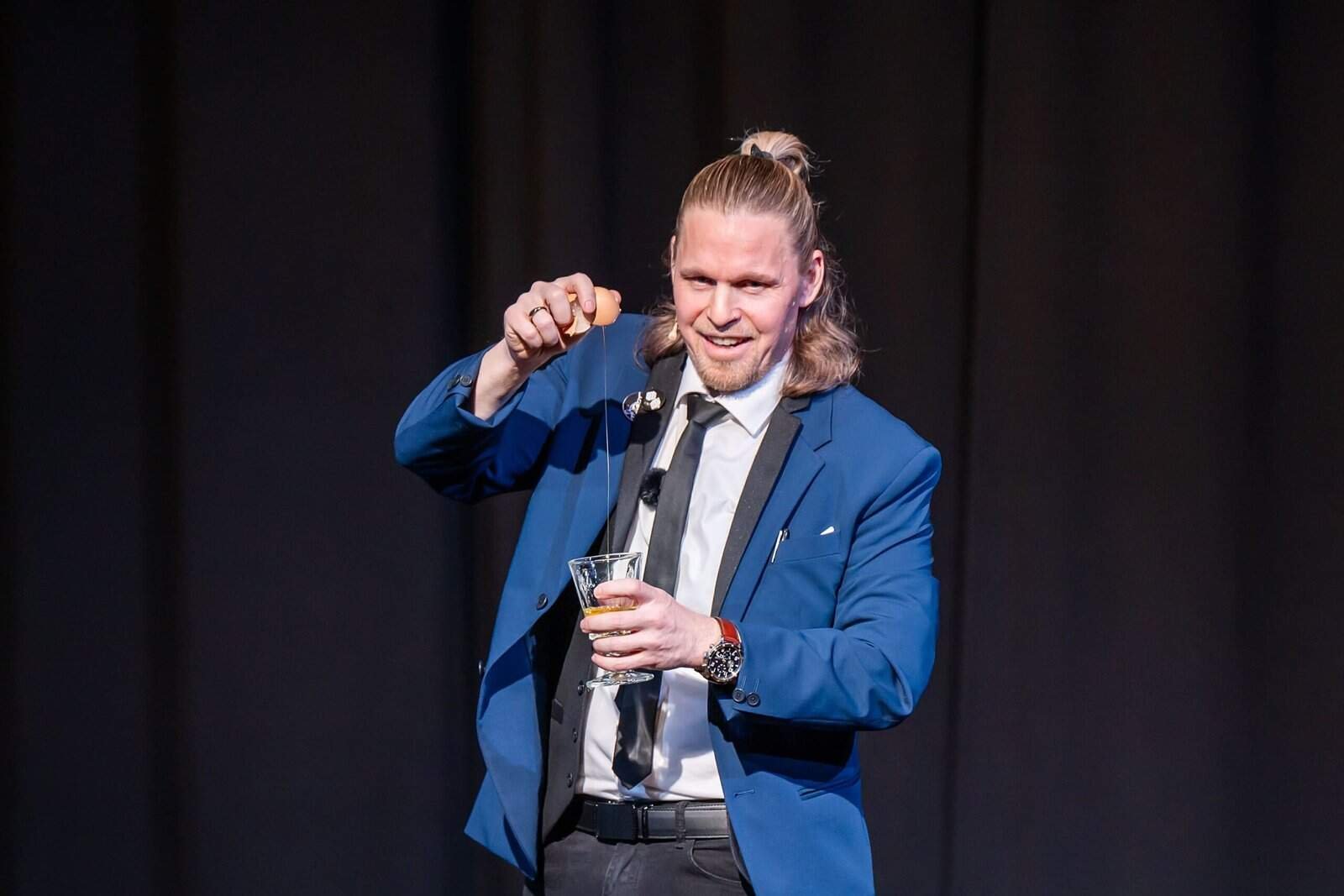 Henry Oz performing close up magic with an egg and glass during a live theater show on Lopez Island