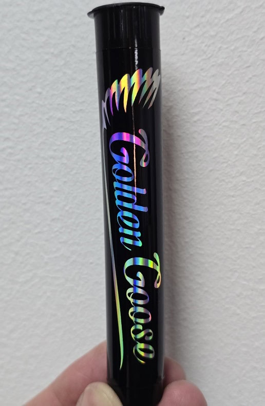 Colorful Golden Goose branded packaging tube with holographic text.