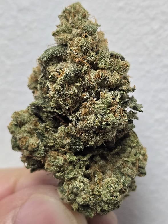 High-quality cannabis bud with dense, frosty trichomes and vibrant green hues.