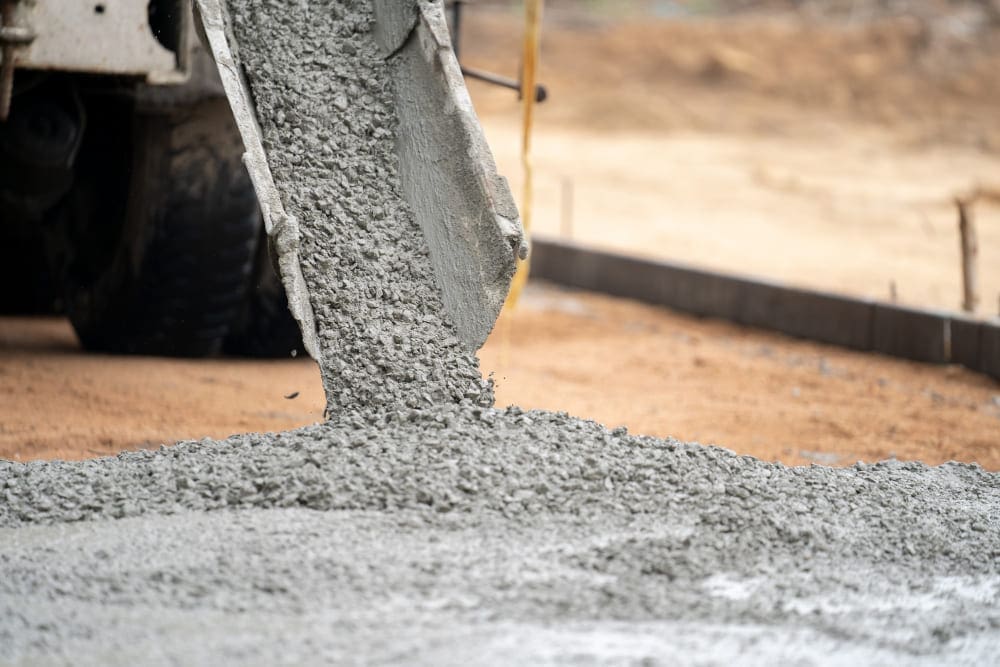 Wet concrete pouring from a chute onto a construction site