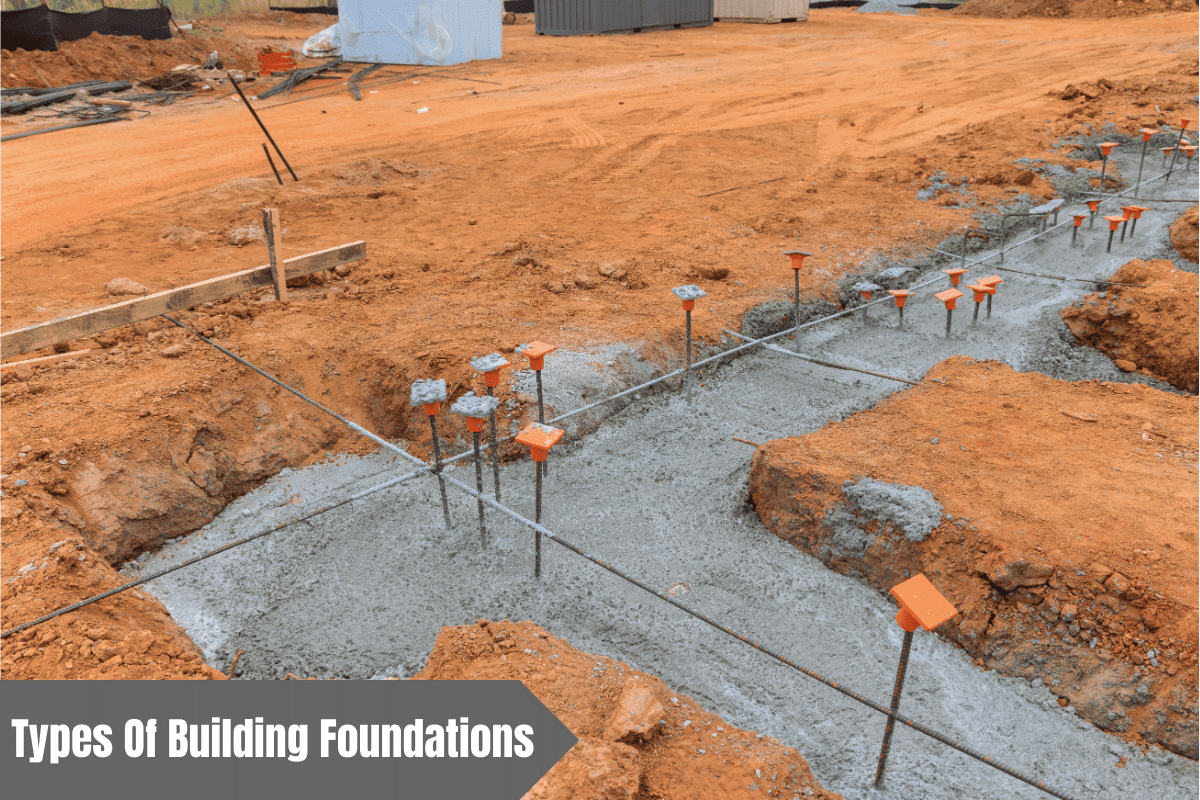 Concrete foundation being poured into a trench at a construction site.