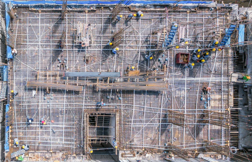 Aerial view of a large construction site with many workers and materials.