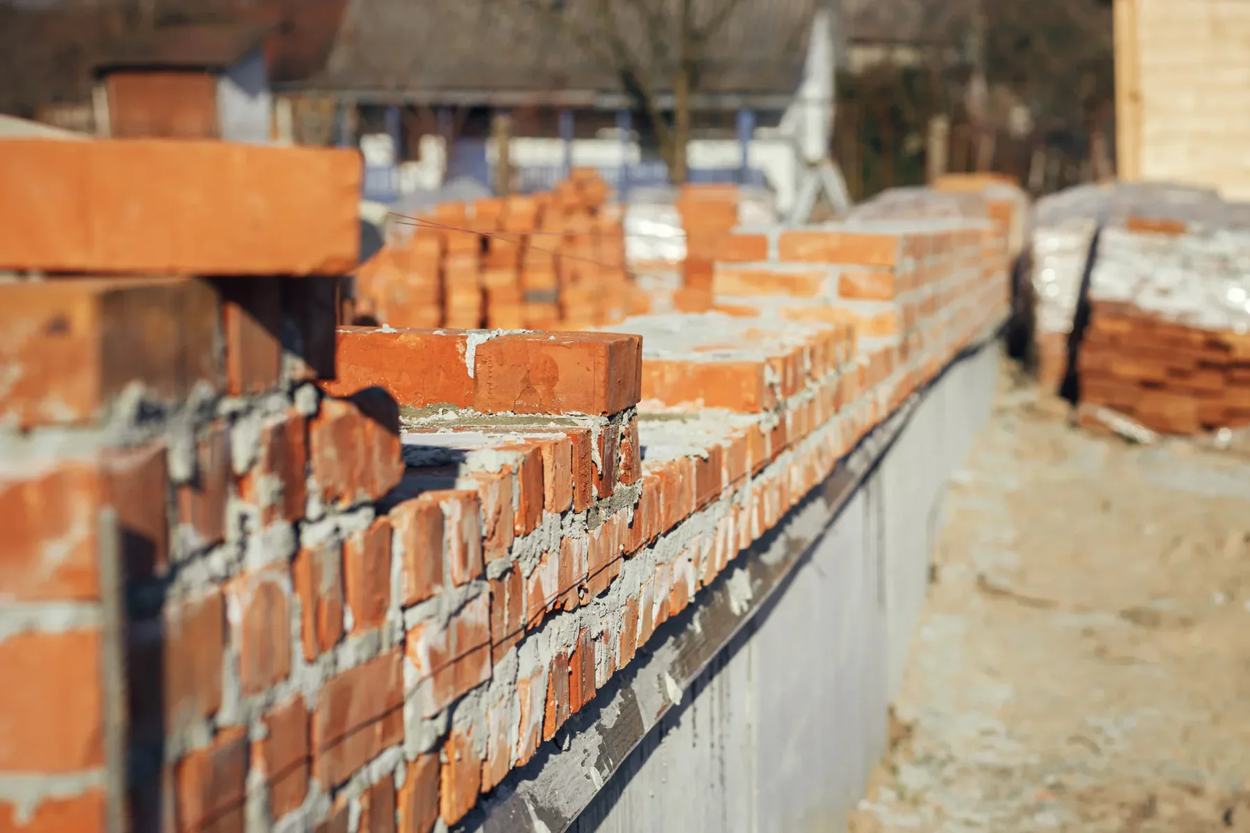 Close-up of a brick wall under construction with mortar joints.