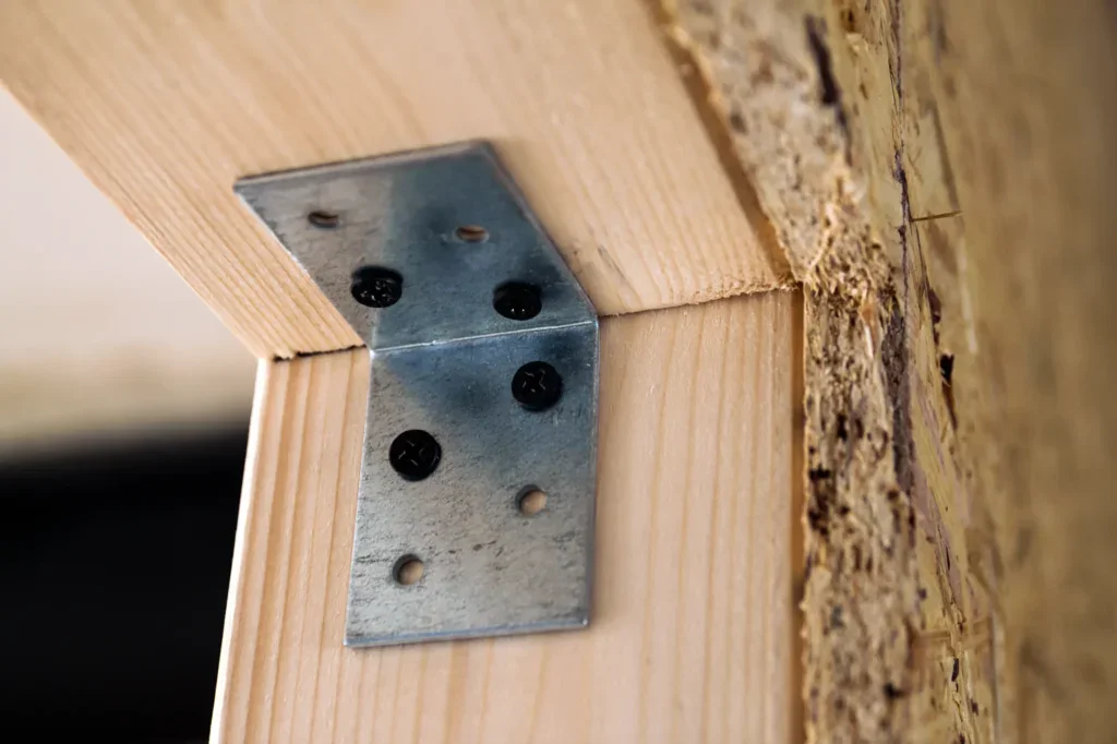 Metal bracket connecting two pieces of wood with screws