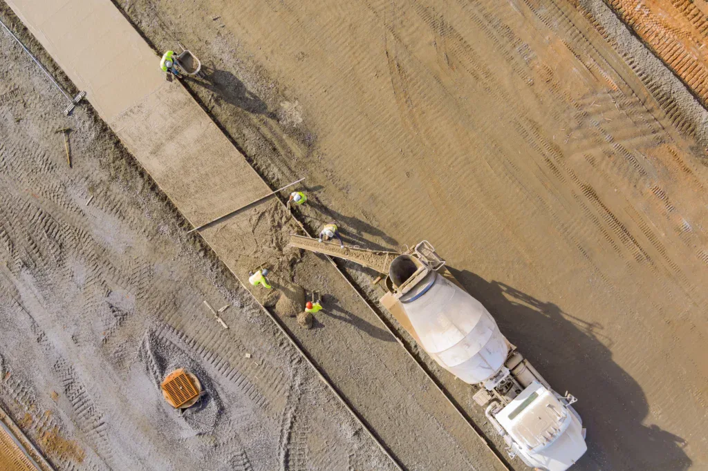 Aerial view of construction workers pouring concrete for a new sidewalk