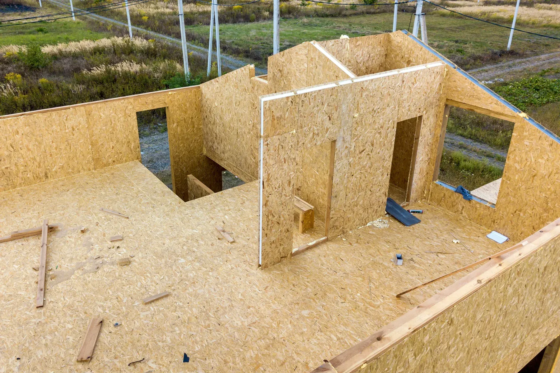 Aerial view of a house under construction with exposed wooden walls