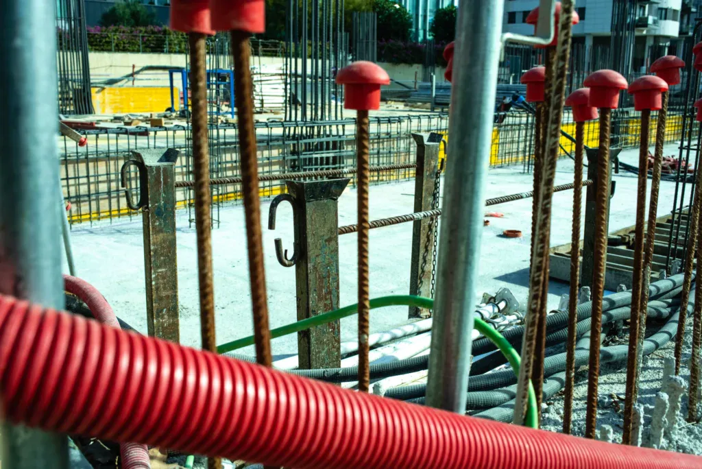 Construction site with rebar, concrete, and red protective caps