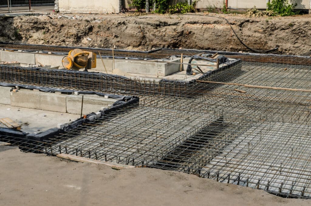 Construction site with rebar grids and concrete foundation work