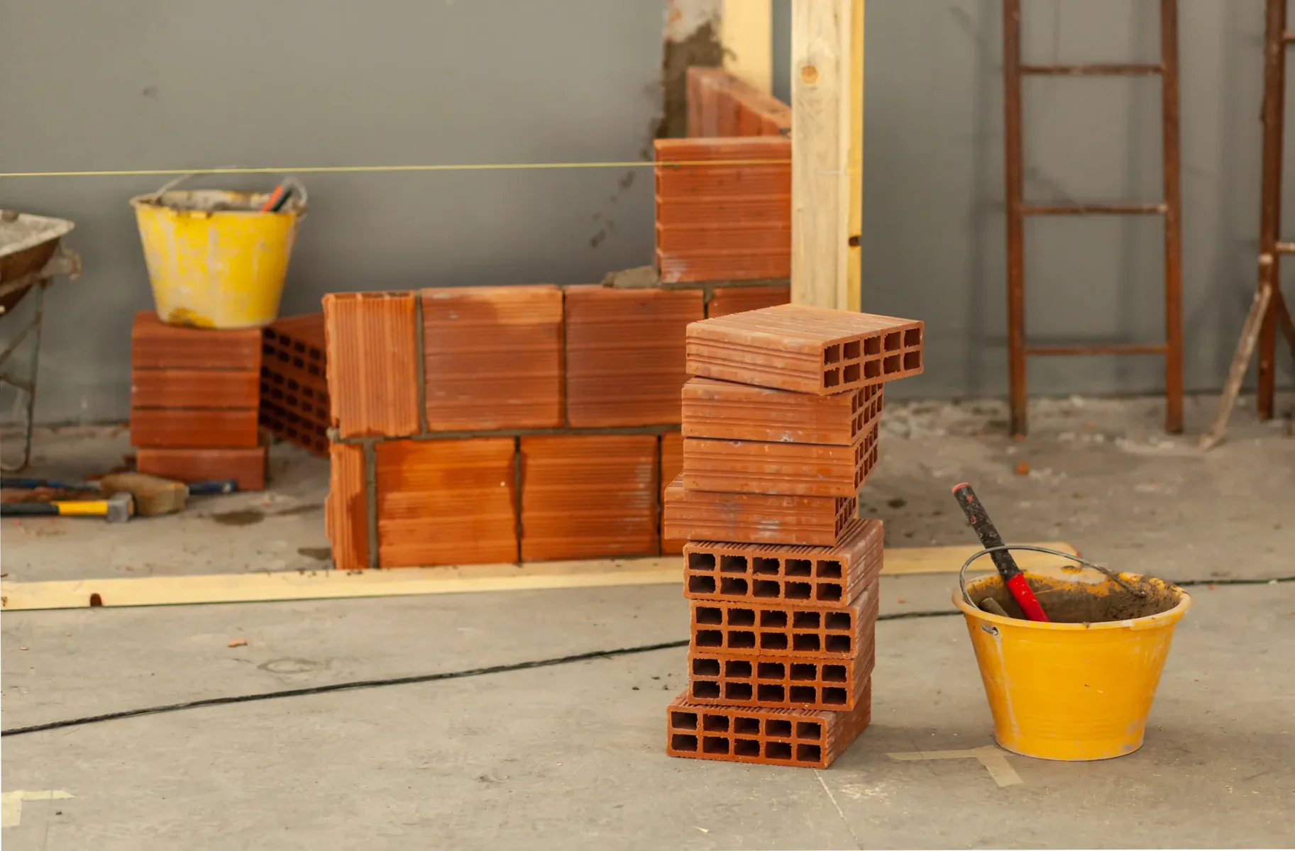 Stack of hollow bricks and construction materials on a concrete floor