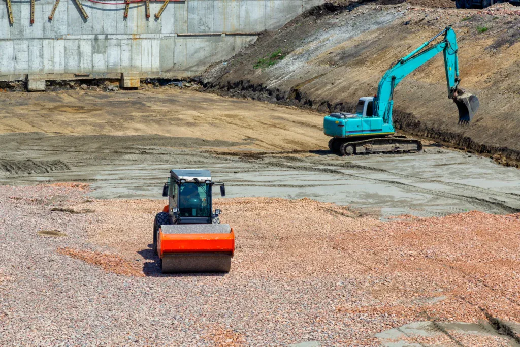 Construction site with a road roller and an excavator