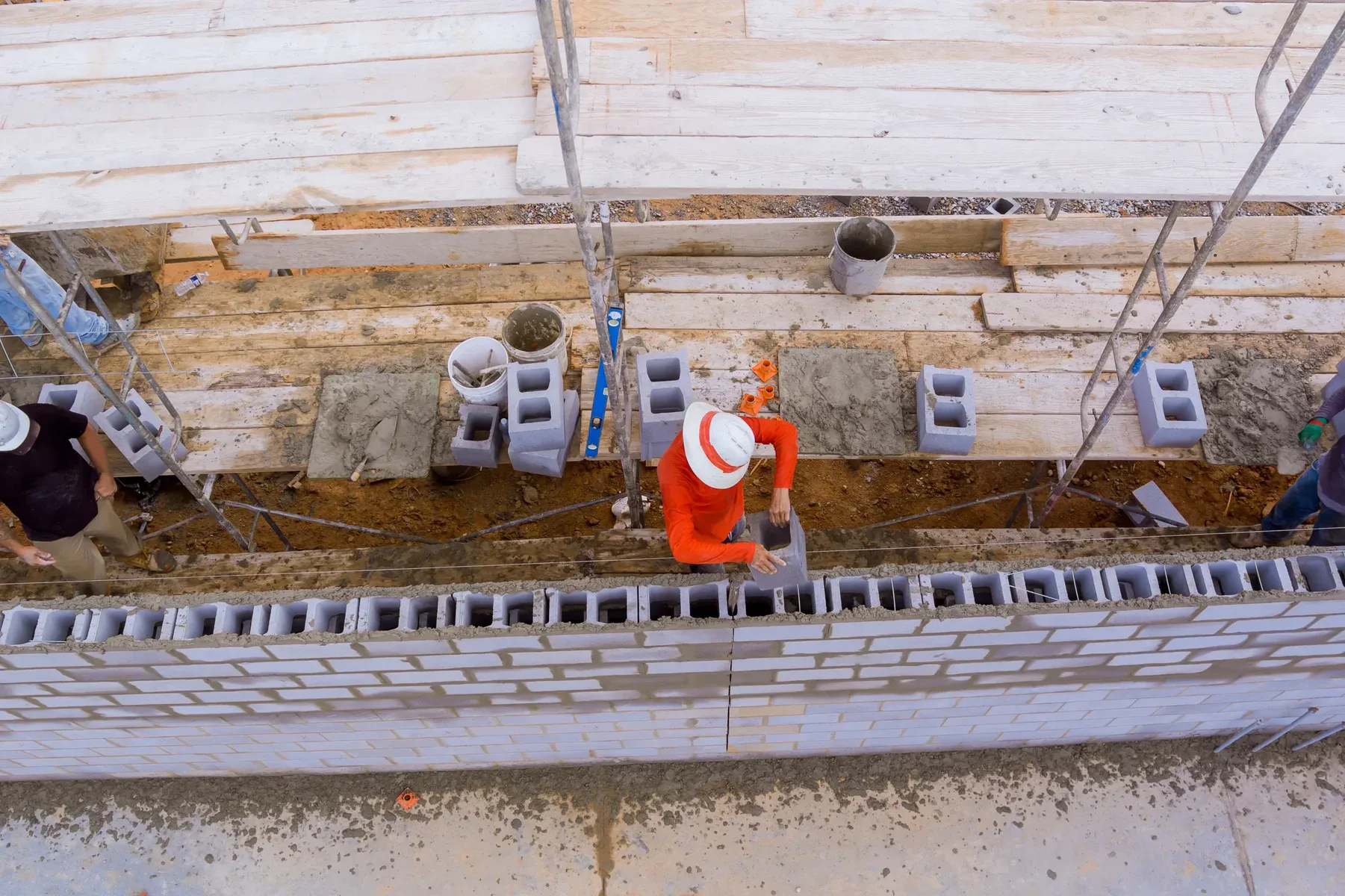 Construction workers building a wall with concrete blocks on a construction site