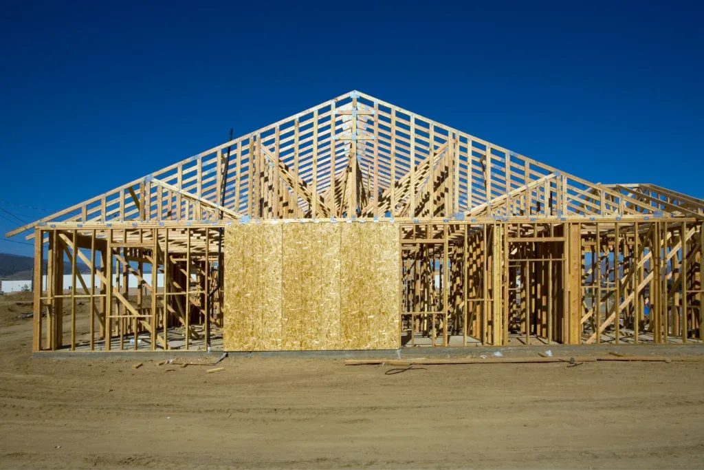 New house under construction with wooden frame against blue sky