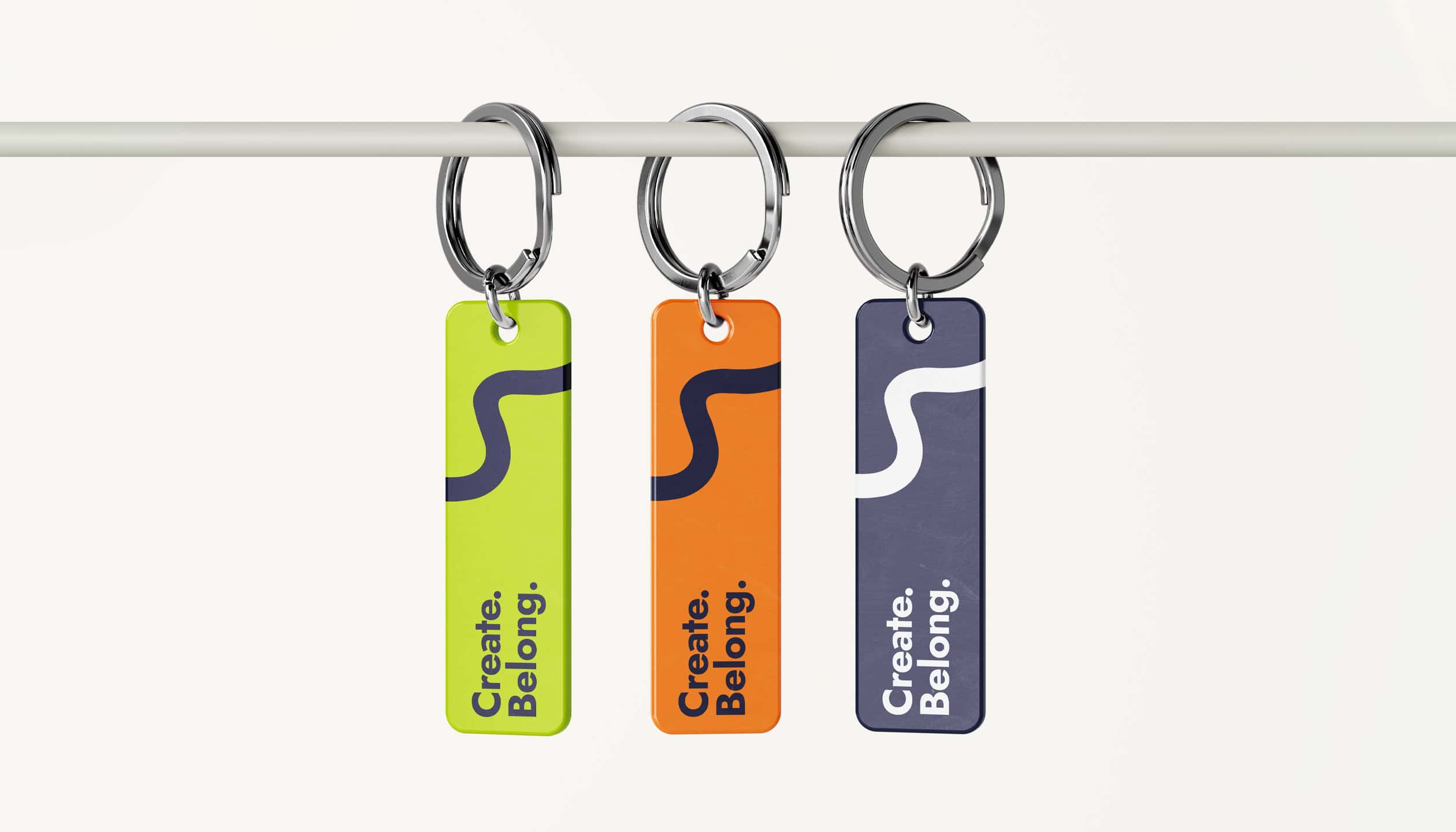 Branded keychains for youth branding collective Vivid Minds, featuring bold curved lines and messages of community and creativity.