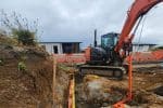 Excavation site with mini excavator for construction building work New Zealand.