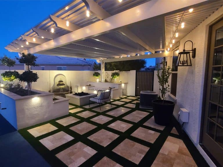 Elegant backyard patio featuring well-manicured plants, outdoor seating, and ambient lighting for a relaxing environment.
