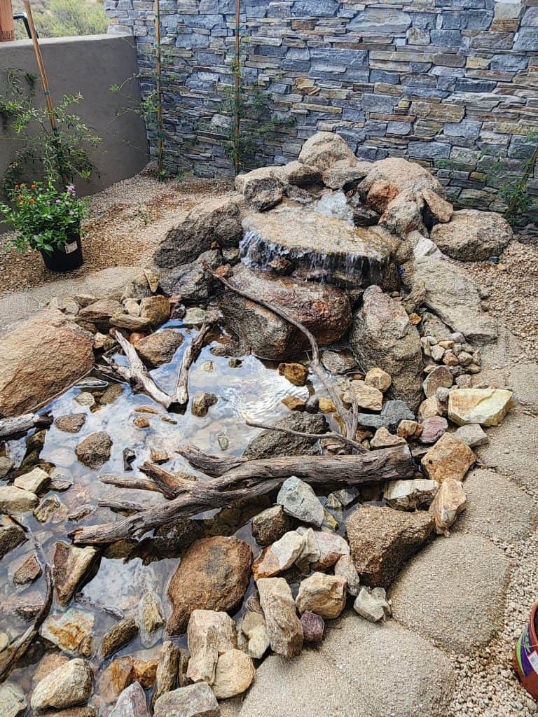 Beautiful landscape with natural rock water feature and waterfall in a backyard.