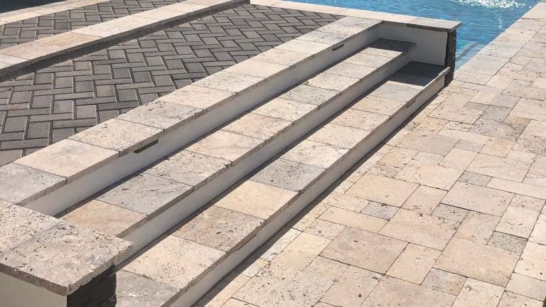 Beautiful stone pool steps and paver patio enhance landscape design by Green Panda Landcape & Design.