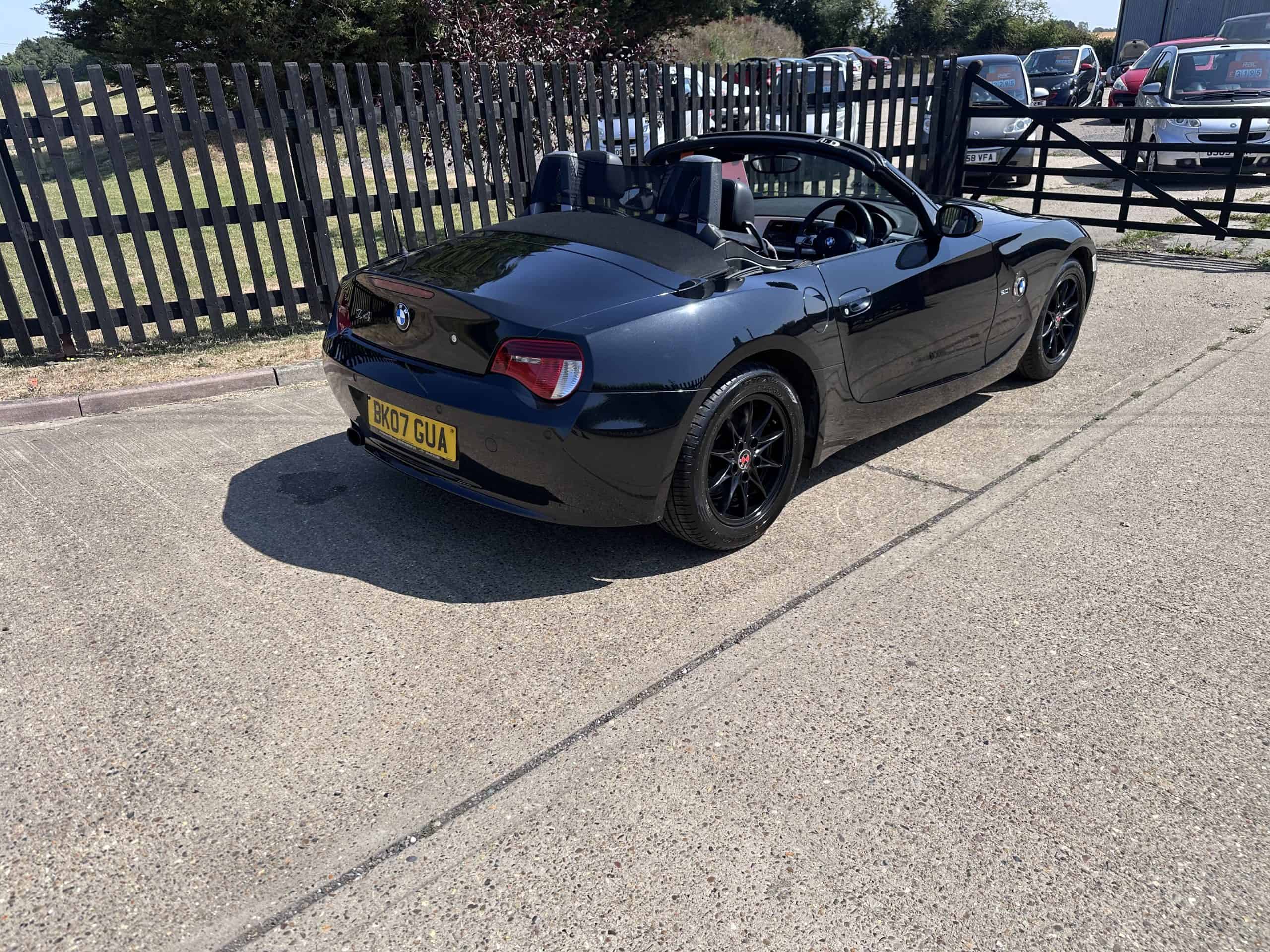 Black BMW Z4 convertible with subtle red features parked outdoors.