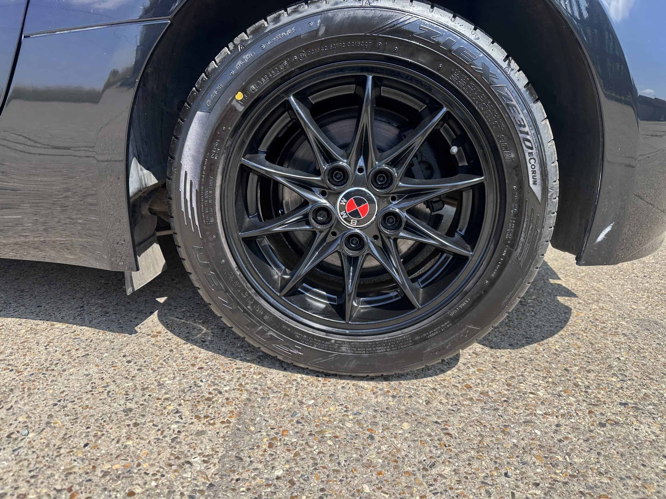 Close-up of black alloy wheel with red center cap on BMW Z4.