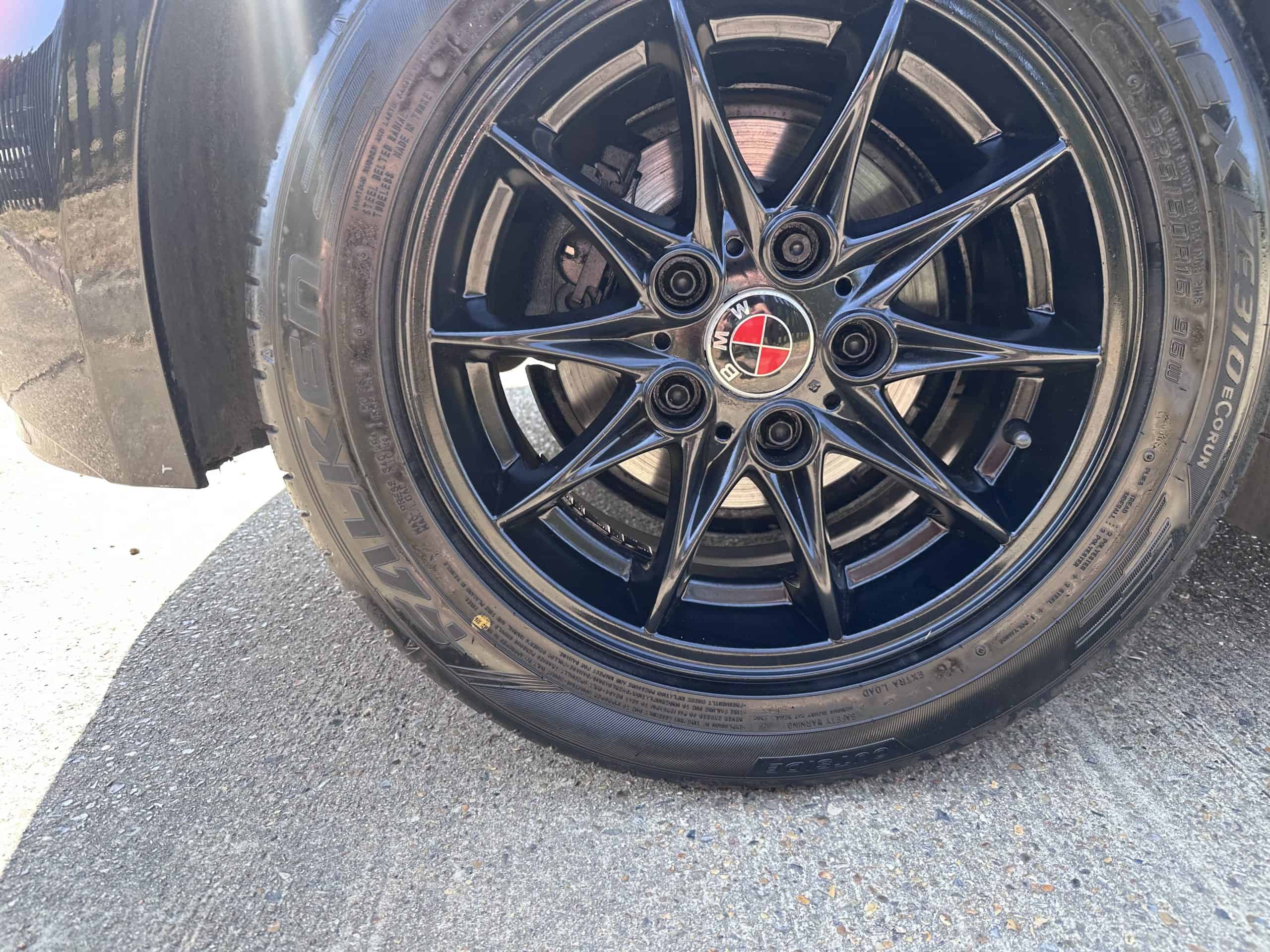 Close-up of BMW Z4 alloy wheel with black finish and red center cap.