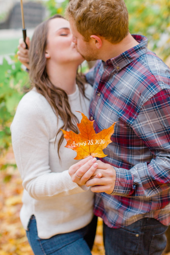 couple kissing in a fall engagement session with wedding date on leaf
- Rainy Day Engagement Session Downtown Ottawa - Photo Locations  Grey Loft Studio - Ottawa Wedding Photographer & Videographer