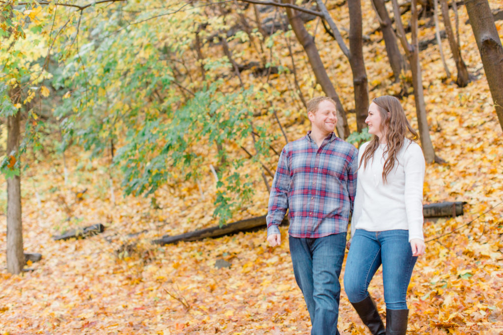 couple walking together in the rain during the fall  Grey Loft Studio - Ottawa Wedding Photographer & Videographer